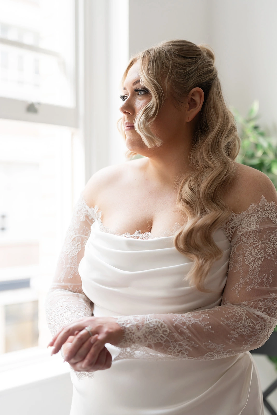 Custom wedding dress with lace sleeve and peekaboo detail, front view of the fitted corset bodice