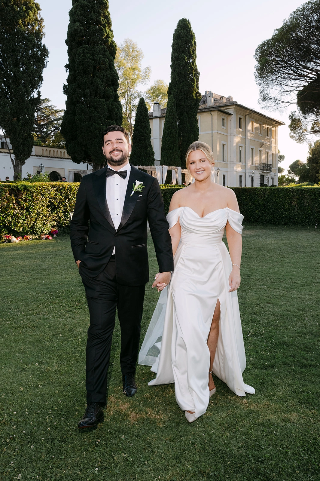 Custom wedding dress with satin drapery and a side split, full-length view at an Italian villa wedding