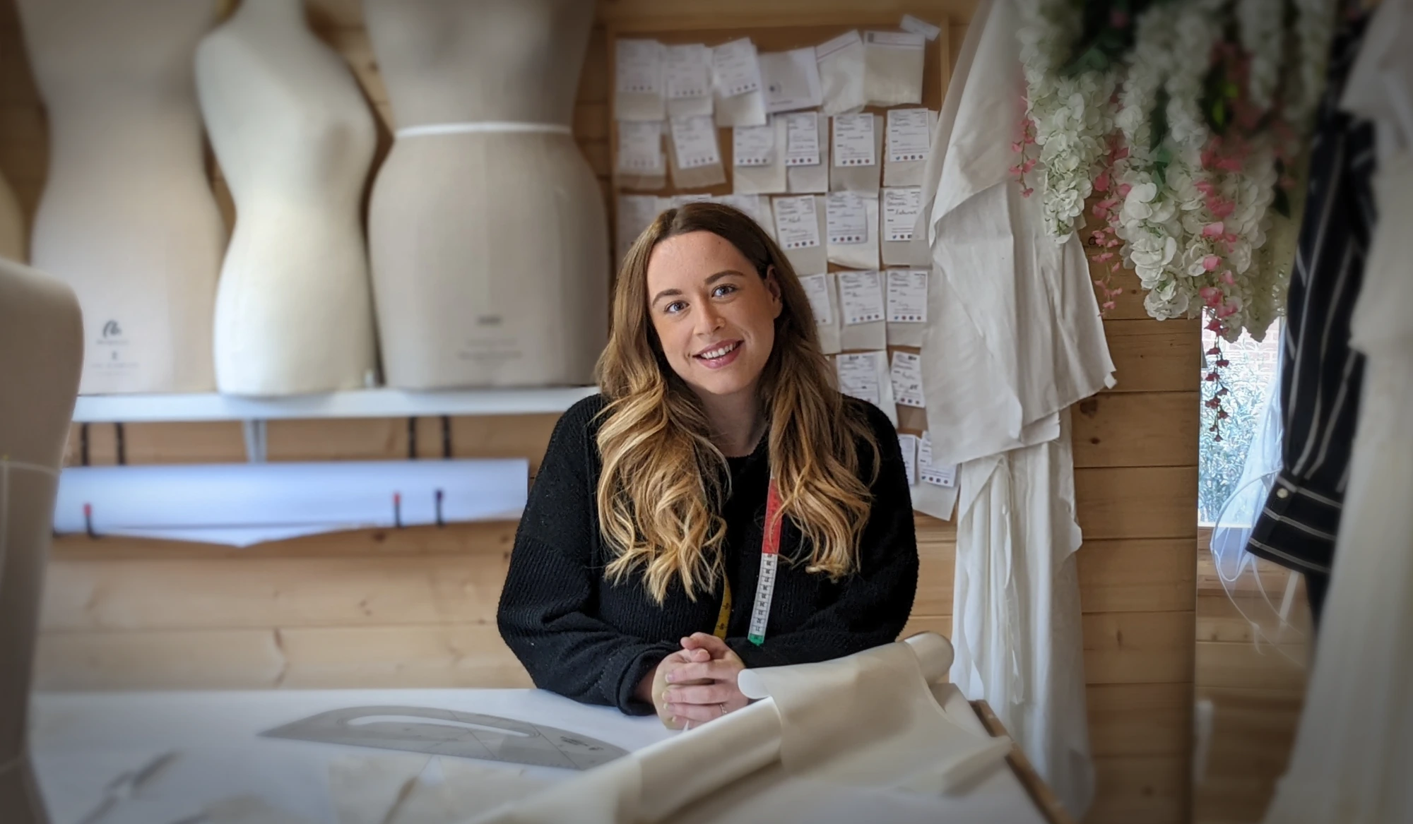 Kate Rosamond, custom bridal designer, at her cutting table in the Hertfordshire studio